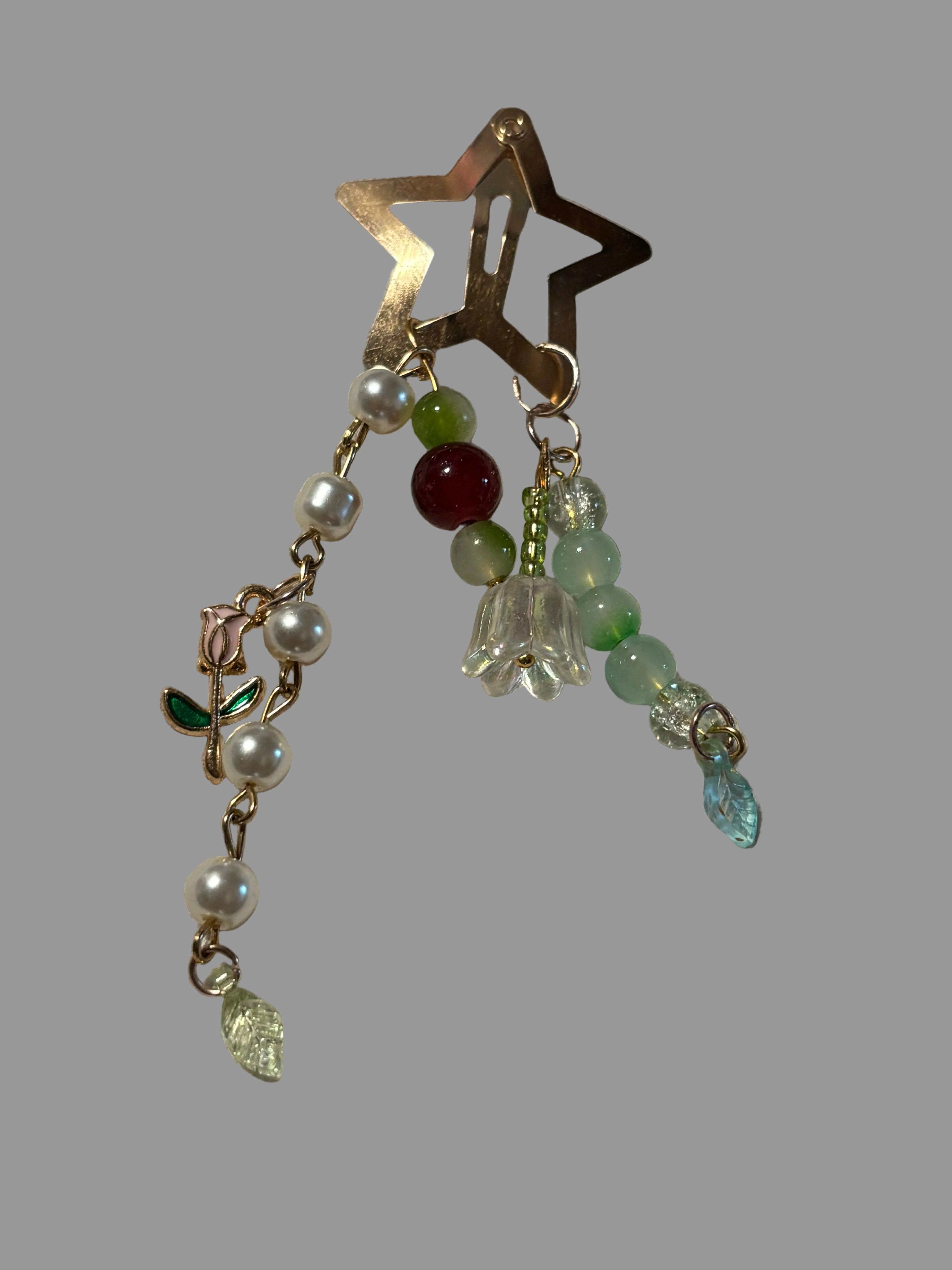 Star-shaped clip with bead and flower decorations on a textured surface